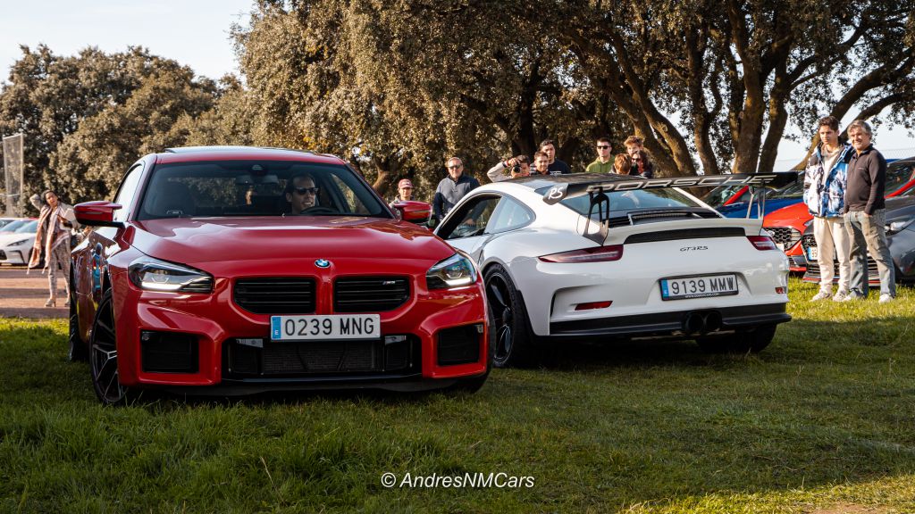 Evento de coches de lujo, BMW M2 y Porsche GT3 RS juntos y rodeados de gente que asistió al evento